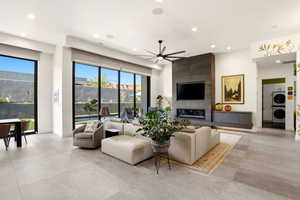 Living area featuring ceiling fan, stacked washer and dryer, and recessed lighting