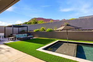 View of swimming pool featuring outdoor furniture, patio surround, a fenced backyard, and a mountain view