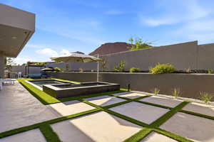 Fenced backyard featuring a patio and an in-ground hot tub