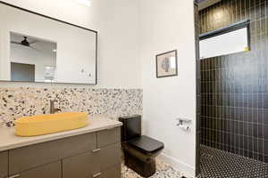 Full bath with vanity, decorative backsplash, and walk in shower