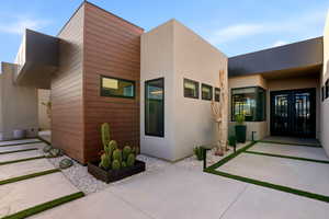 Property entrance with stucco siding, a patio area, and french doors