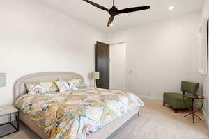 Bedroom with light carpet, ceiling fan, and recessed lighting