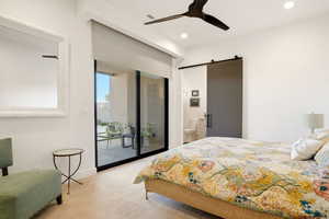 Bedroom with a barn door, access to outside, ceiling fan, recessed lighting, and light colored carpet