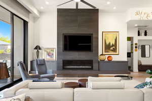 Living area with a large fireplace, a ceiling fan, and recessed lighting