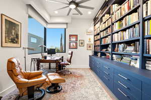 Office with a ceiling fan and baseboards