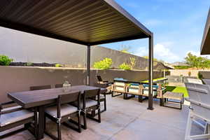 Fenced backyard with outdoor dining space and a patio