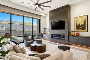 Living area with a fireplace, a ceiling fan, and recessed lighting
