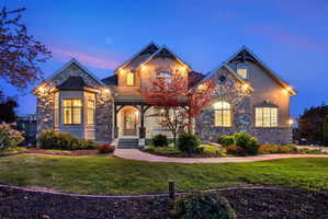 French country inspired facade featuring stone siding, a front yard, and brick siding