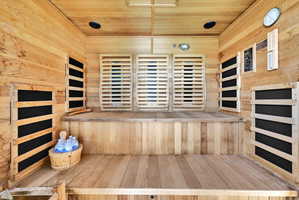 Sauna with wood ceiling, hardwood / wood-style flooring, and wood walls