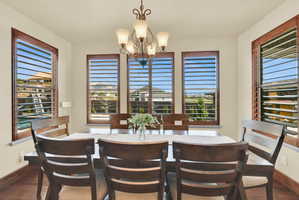 Dining area with wood finished floors, a chandelier, and plenty of natural light
