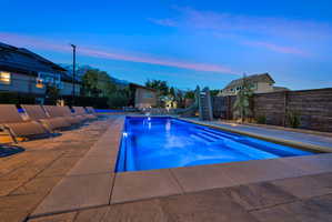 View of pool featuring a water slide and a fenced backyard
