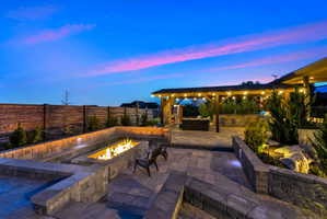 Fenced backyard featuring an outdoor fire pit, a patio, and an outdoor kitchen with living area