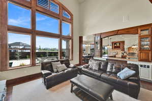 Living room with dark wood finished floors, a chandelier, and a high ceiling