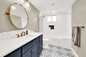 Full bathroom with vanity, shower / tub combo, and light tile patterned flooring