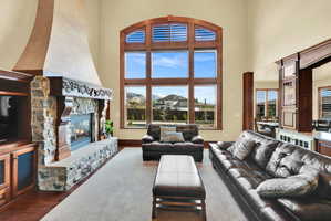 Living area with a high ceiling, a fireplace, and dark wood finished floors
