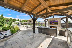 Fenced backyard featuring an outdoor living space with a fireplace and a patio