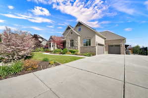 View of front of house with a garage, concrete driveway, brick siding, and stucco siding