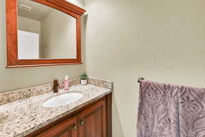 Bathroom with vanity and a textured wall
