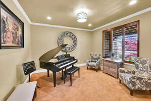 Sitting room featuring light colored carpet, crown molding, and recessed lighting