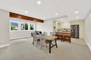 Dining area with light colored carpet, recessed lighting, and beam ceiling