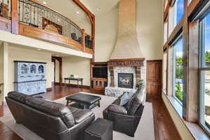 Living area featuring a fireplace, a high ceiling, wood-type flooring, recessed lighting, and arched walkways