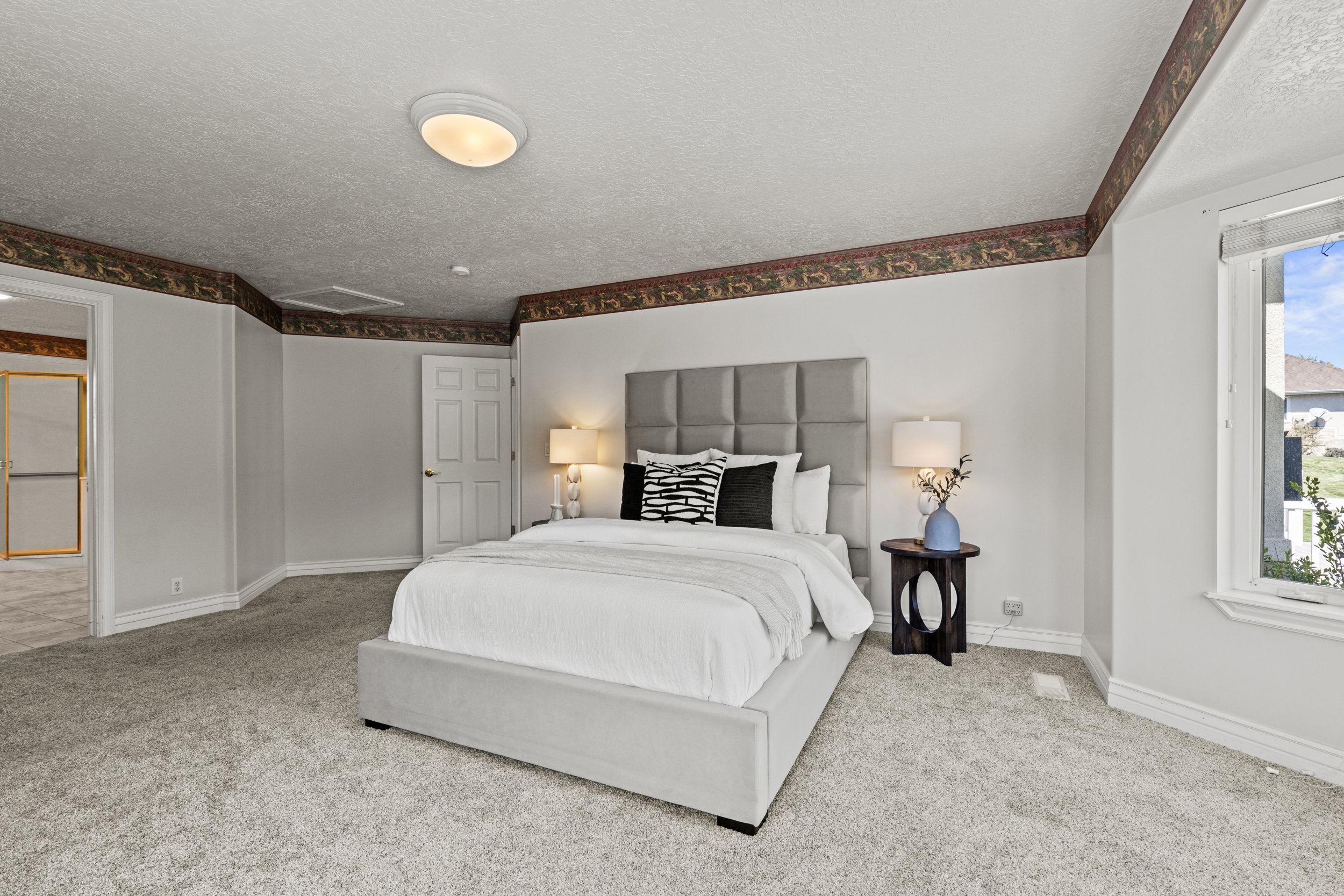 Bedroom featuring light carpet and a textured ceiling