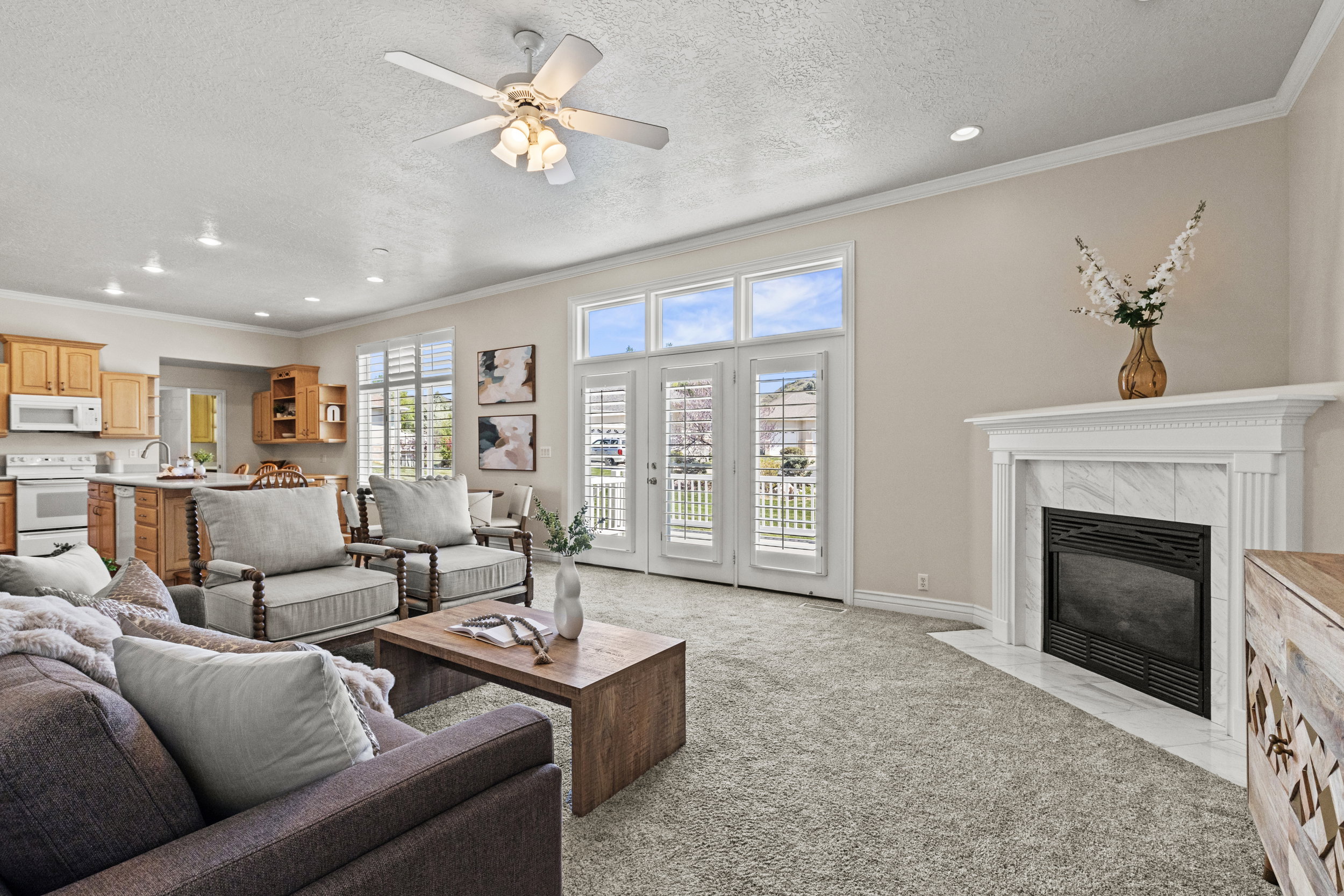 Living room featuring ceiling fan, light colored carpet, recessed lighting, a high end fireplace, and ornamental molding