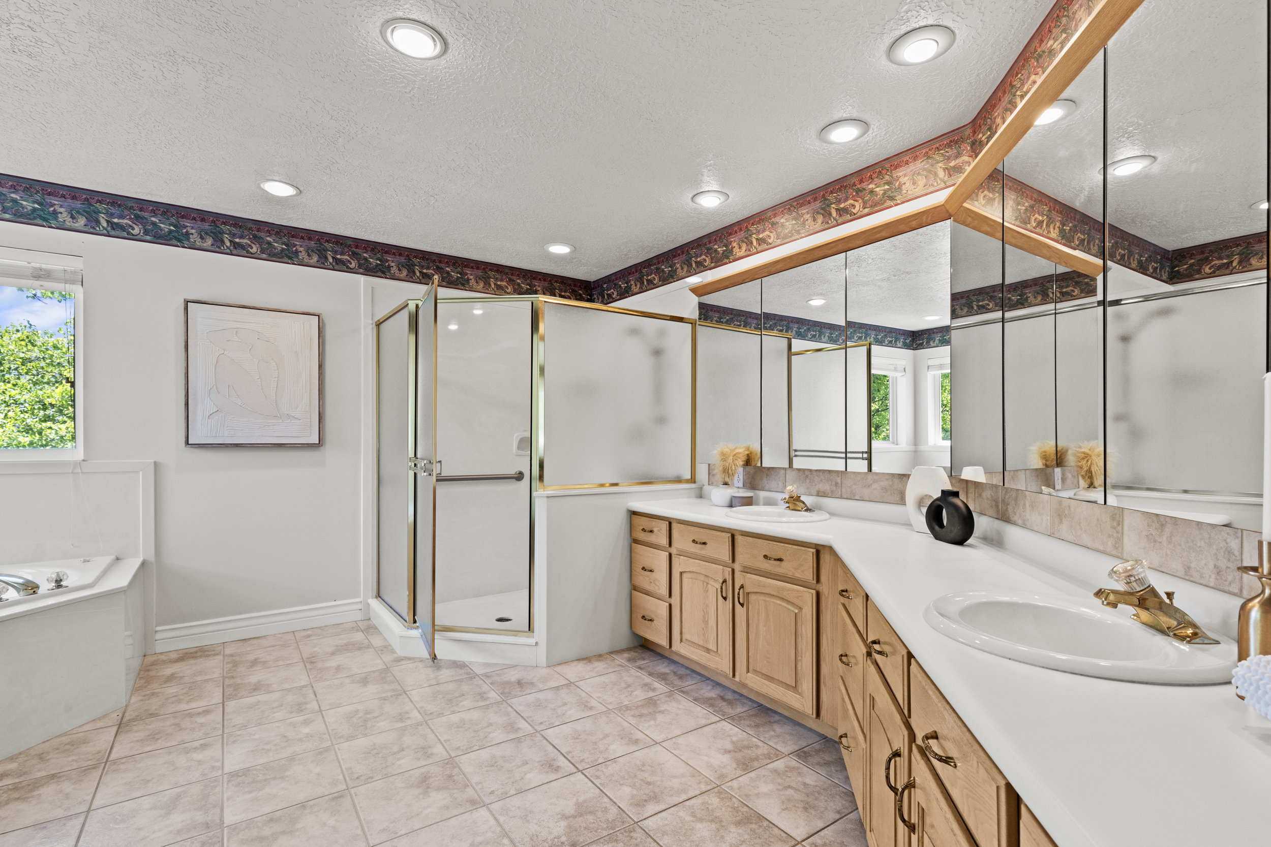 Bathroom with a textured ceiling, double vanity, a shower stall, a garden tub, and light tile patterned floors