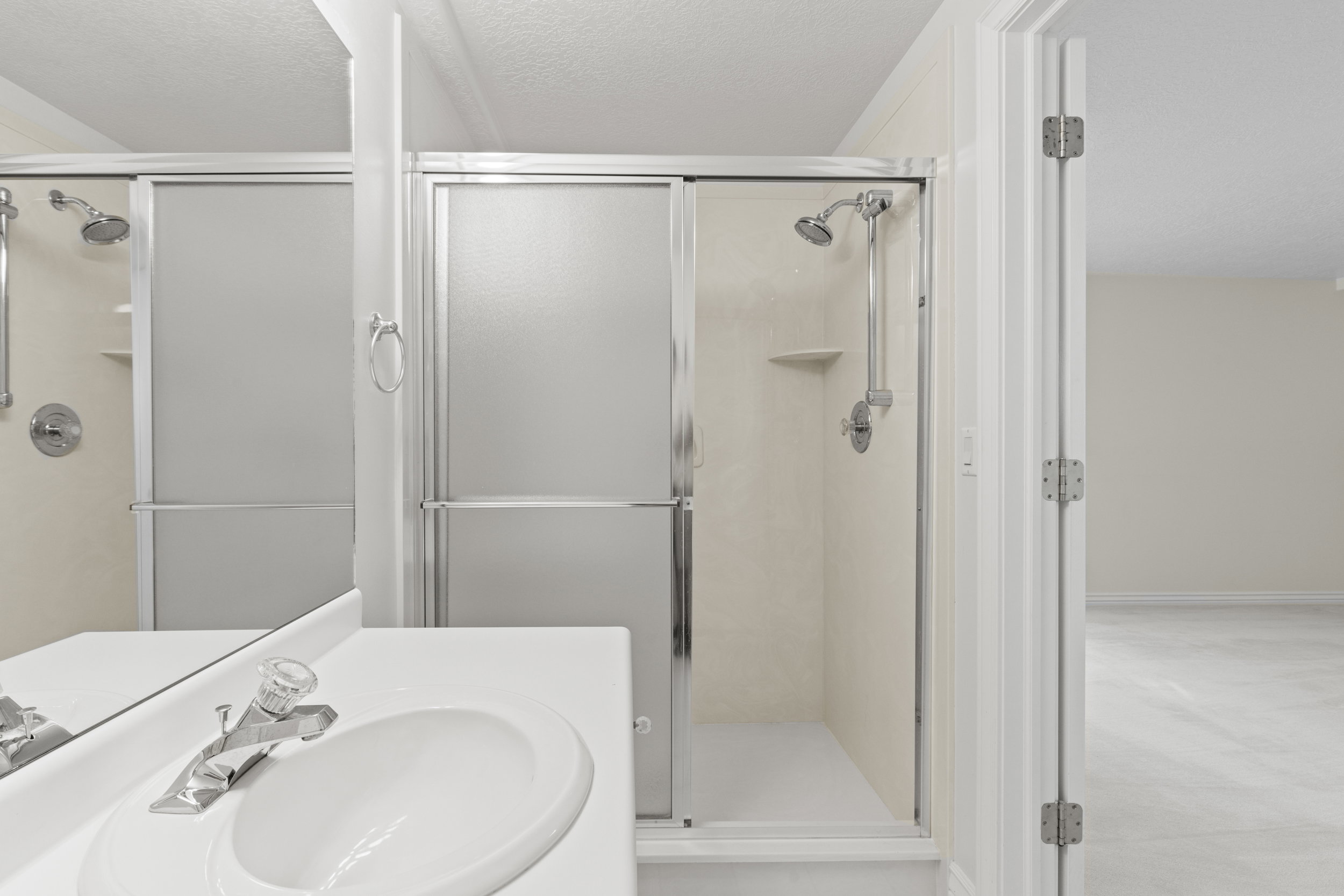 Bathroom featuring vanity, a shower stall, and a textured ceiling