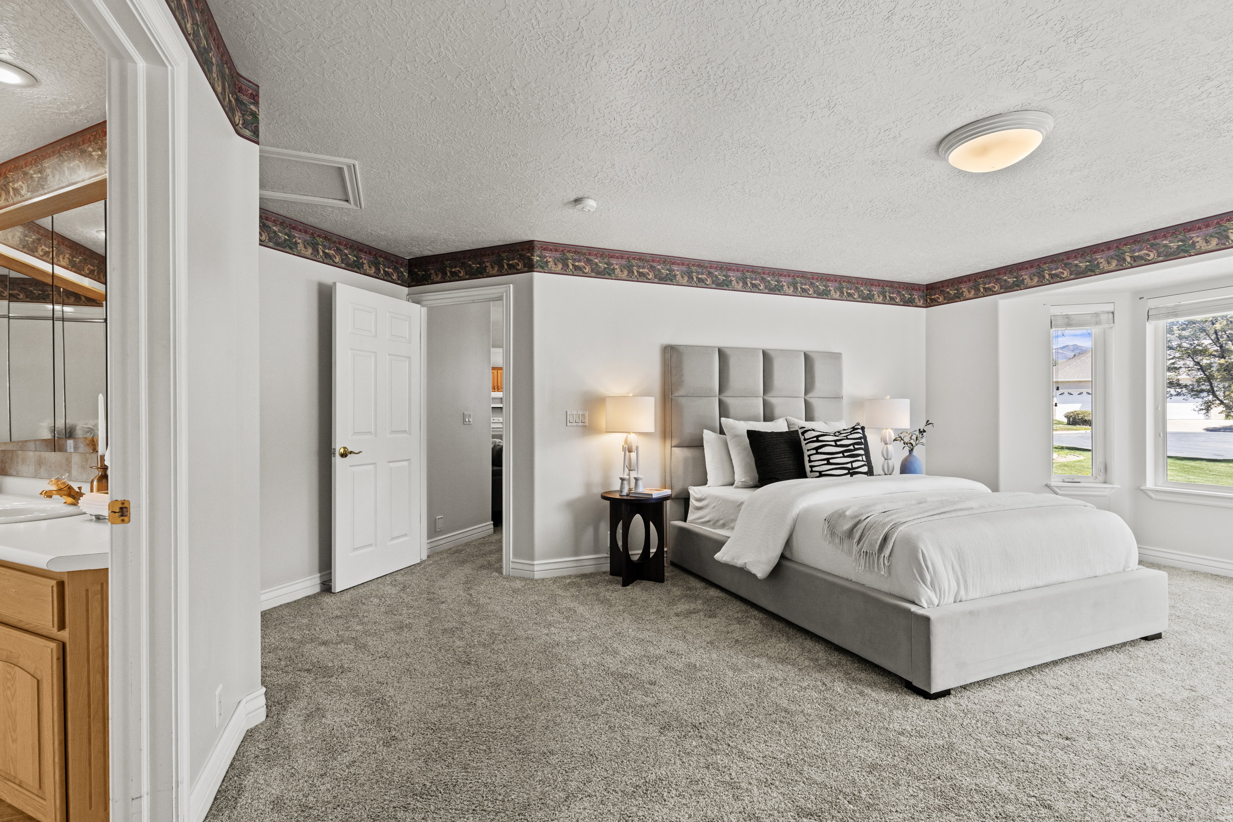 Bedroom with light colored carpet and a textured ceiling