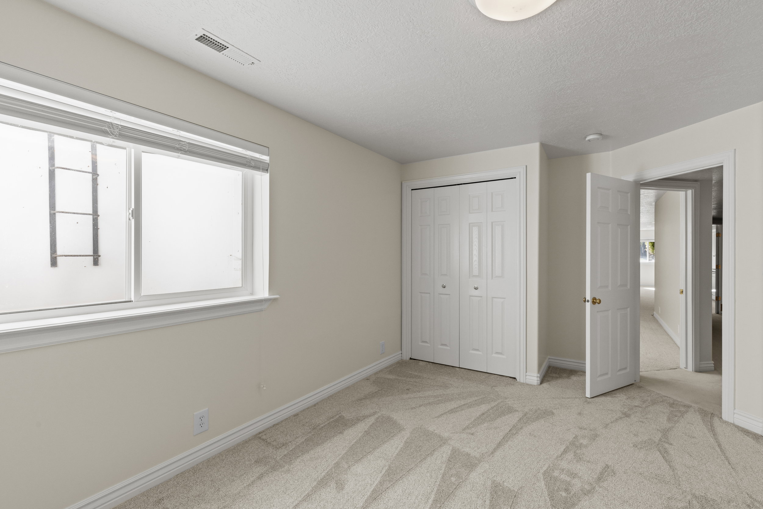 Unfurnished bedroom with light carpet, a textured ceiling, and a closet