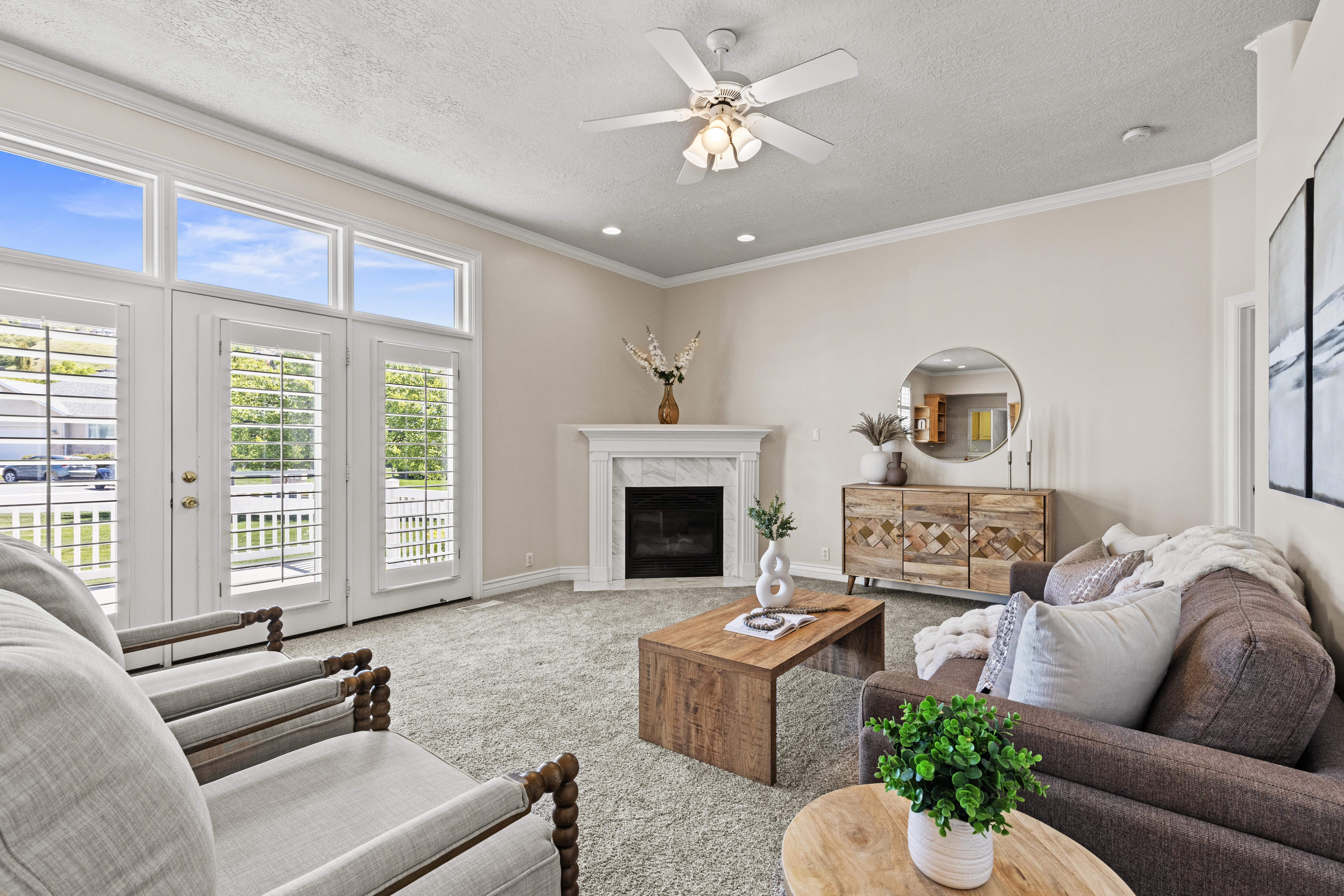 Carpeted living area with a ceiling fan, ornamental molding, a premium fireplace, and a textured ceiling
