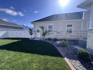 Rear view of property featuring a gate, a mountain view, roof with shingles, a fenced backyard, and stone siding