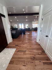 Corridor featuring wood finished floors, healthy amount of natural light, recessed lighting, and a barn door