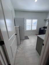 Kitchen with freestanding refrigerator and light stone counters