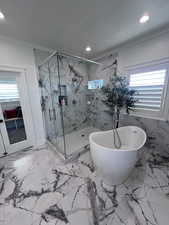 Full bath with a marble finish shower, recessed lighting, a freestanding tub, and ornamental molding