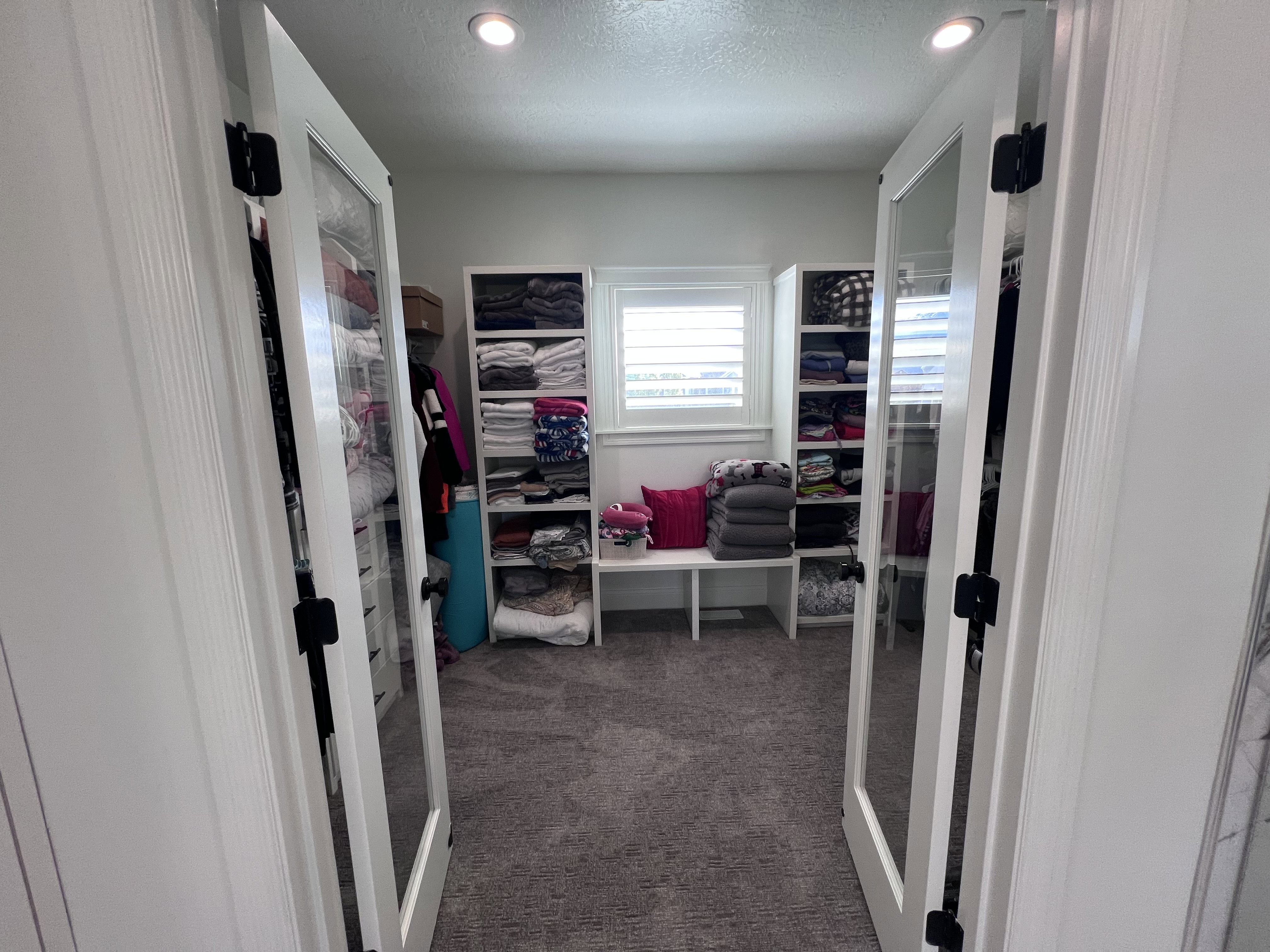 Walk in closet featuring dark colored carpet and french doors