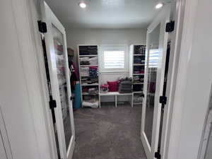 Walk in closet featuring dark colored carpet and french doors