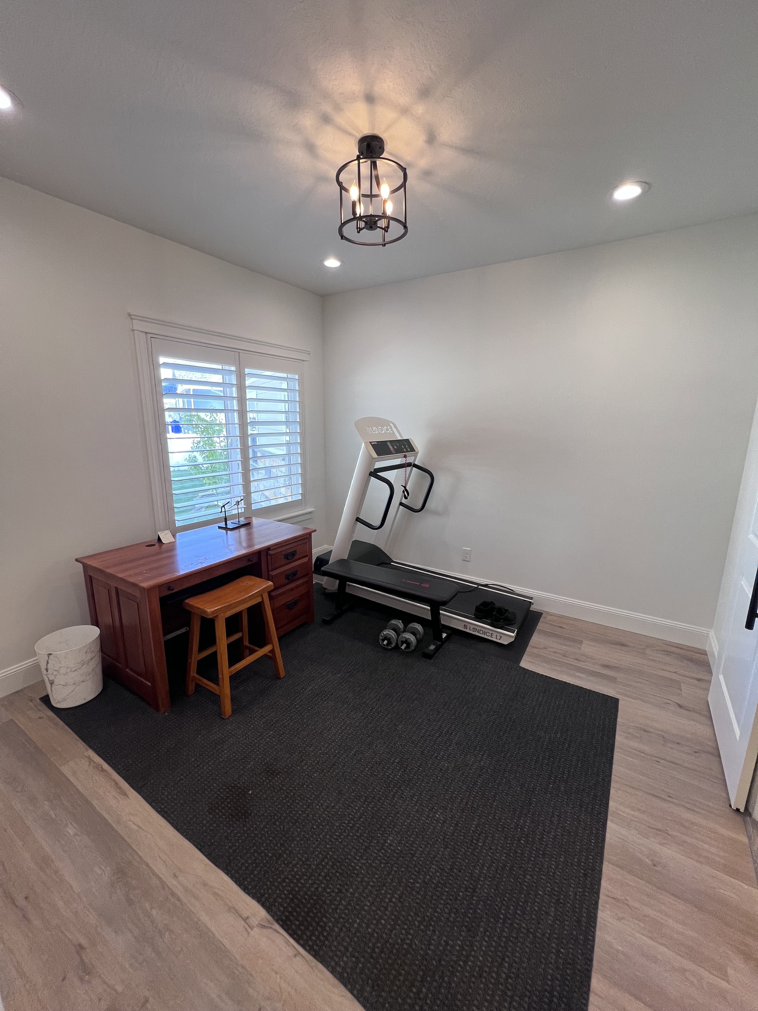 Workout area featuring wood finished floors and suspended lighting