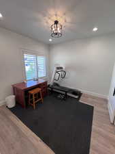 Workout area featuring wood finished floors and suspended lighting