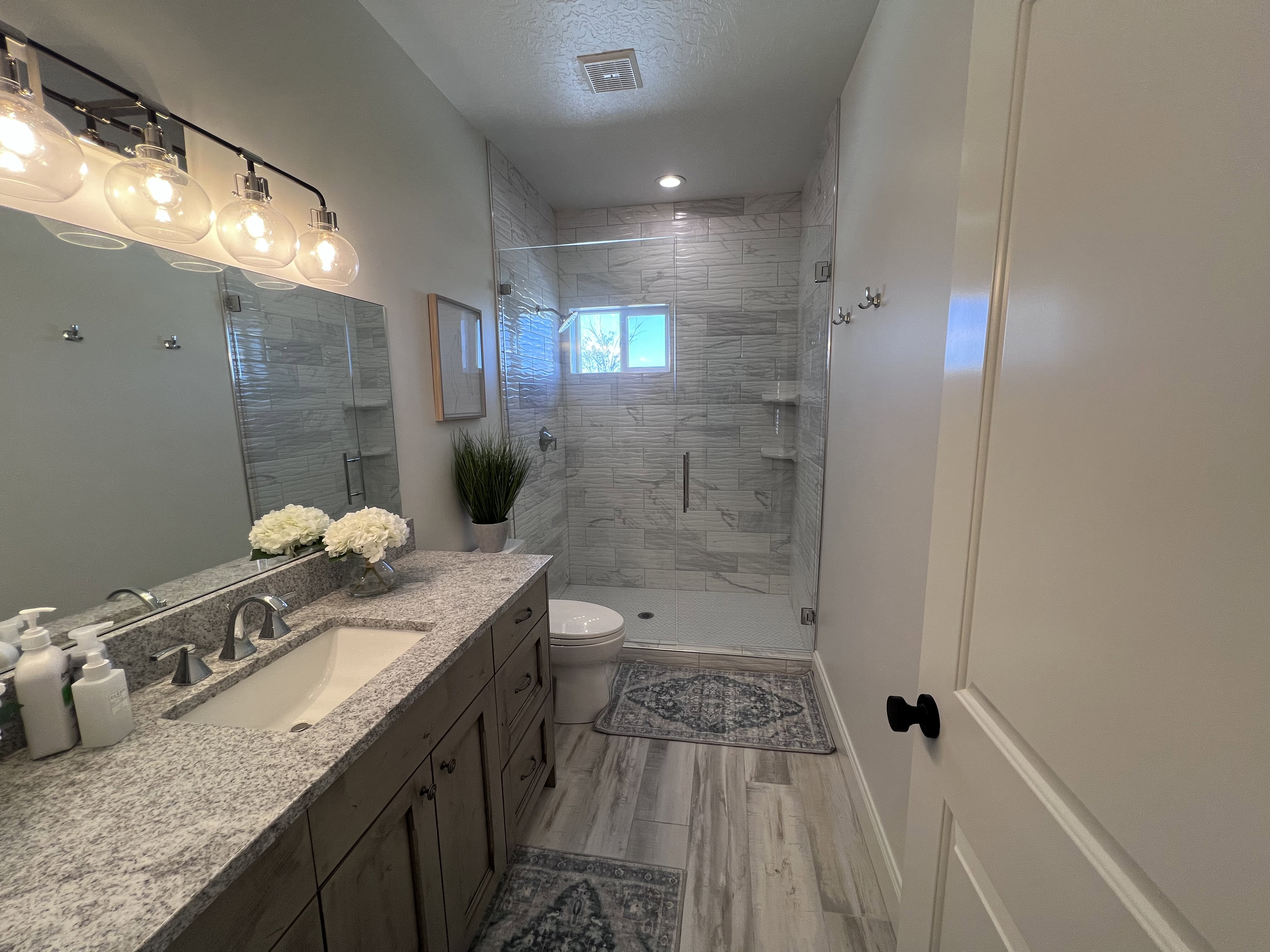Bathroom featuring a shower stall, vanity, a textured ceiling, and light wood finished floors