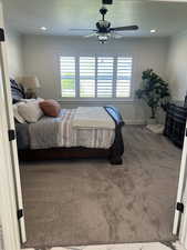Carpeted bedroom featuring ornamental molding and ceiling fan