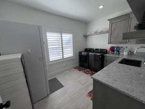 Laundry area featuring independent washer and dryer, cabinet space, and recessed lighting