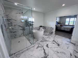 Full bath featuring a wainscoted wall, a marble finish shower, ensuite bath, tile walls, and recessed lighting