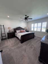 Bedroom featuring ceiling fan, recessed lighting, dark colored carpet, and ornamental molding