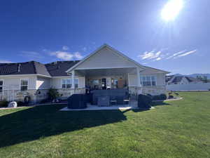 Back of property with stone siding and a patio