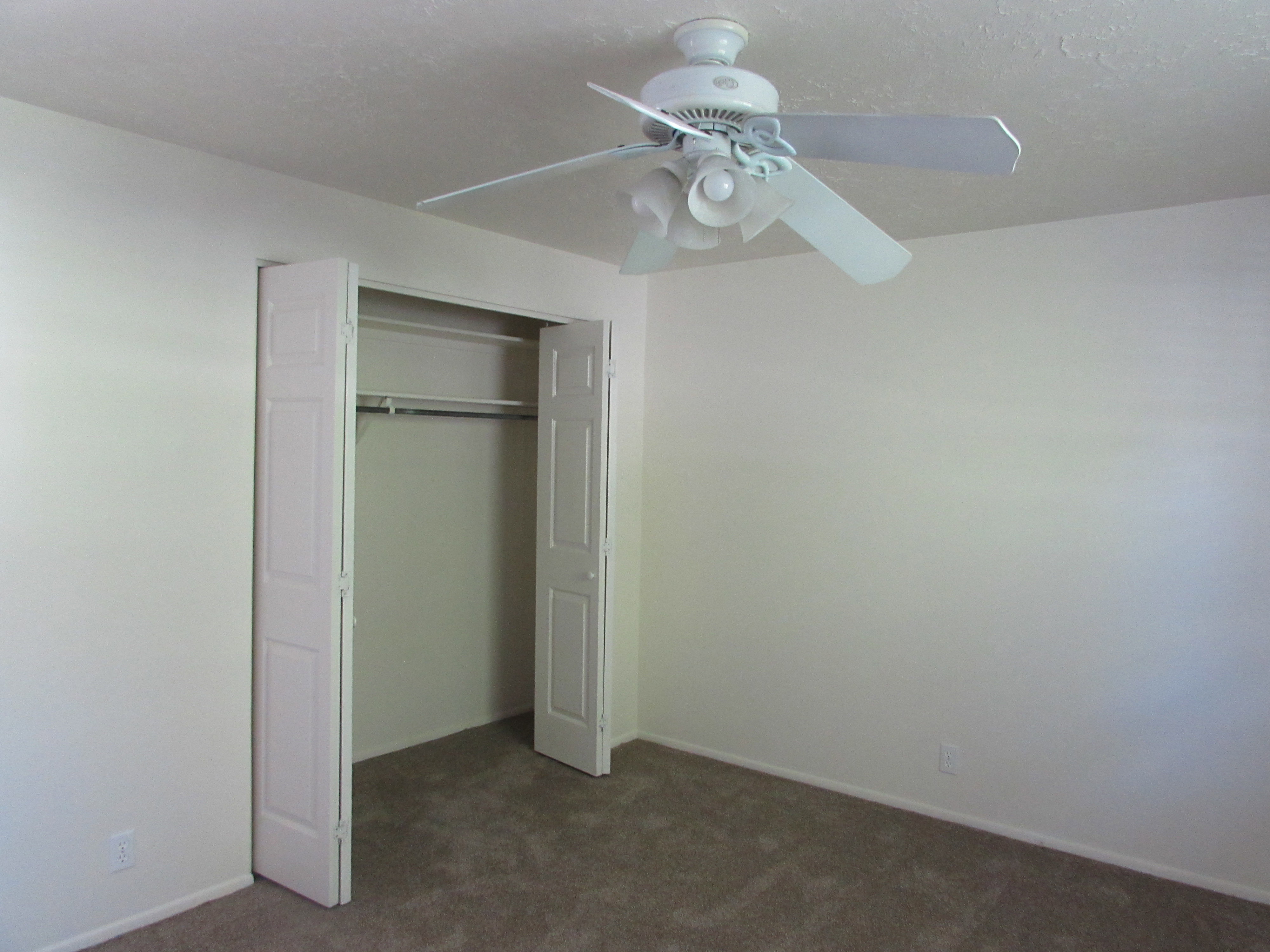 Bedroom with new carpet, a closet, and a ceiling fan