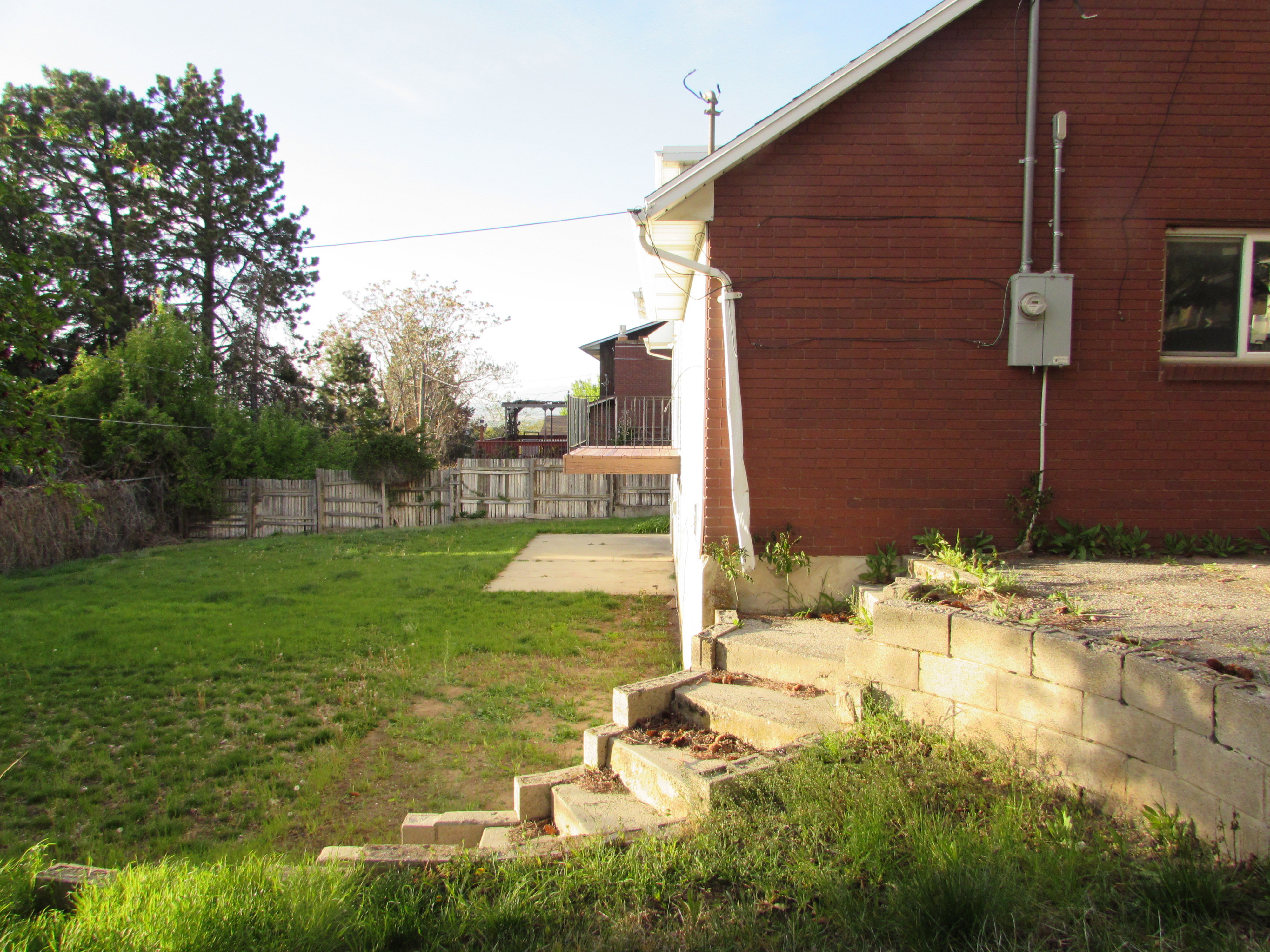 Fenced backyard featuring a patio with wooden balcony off the kitchen