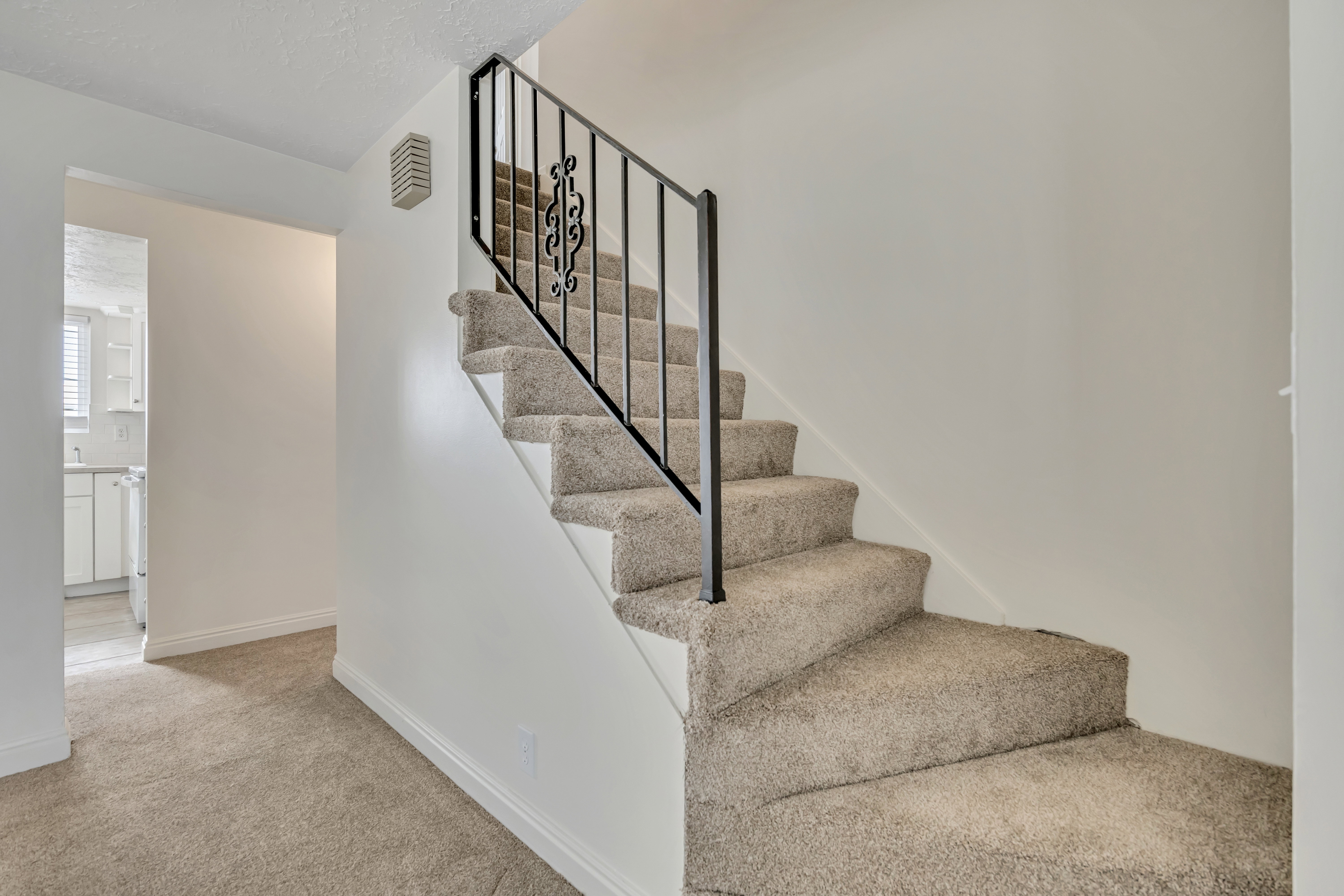 Staircase with carpet floors and baseboards