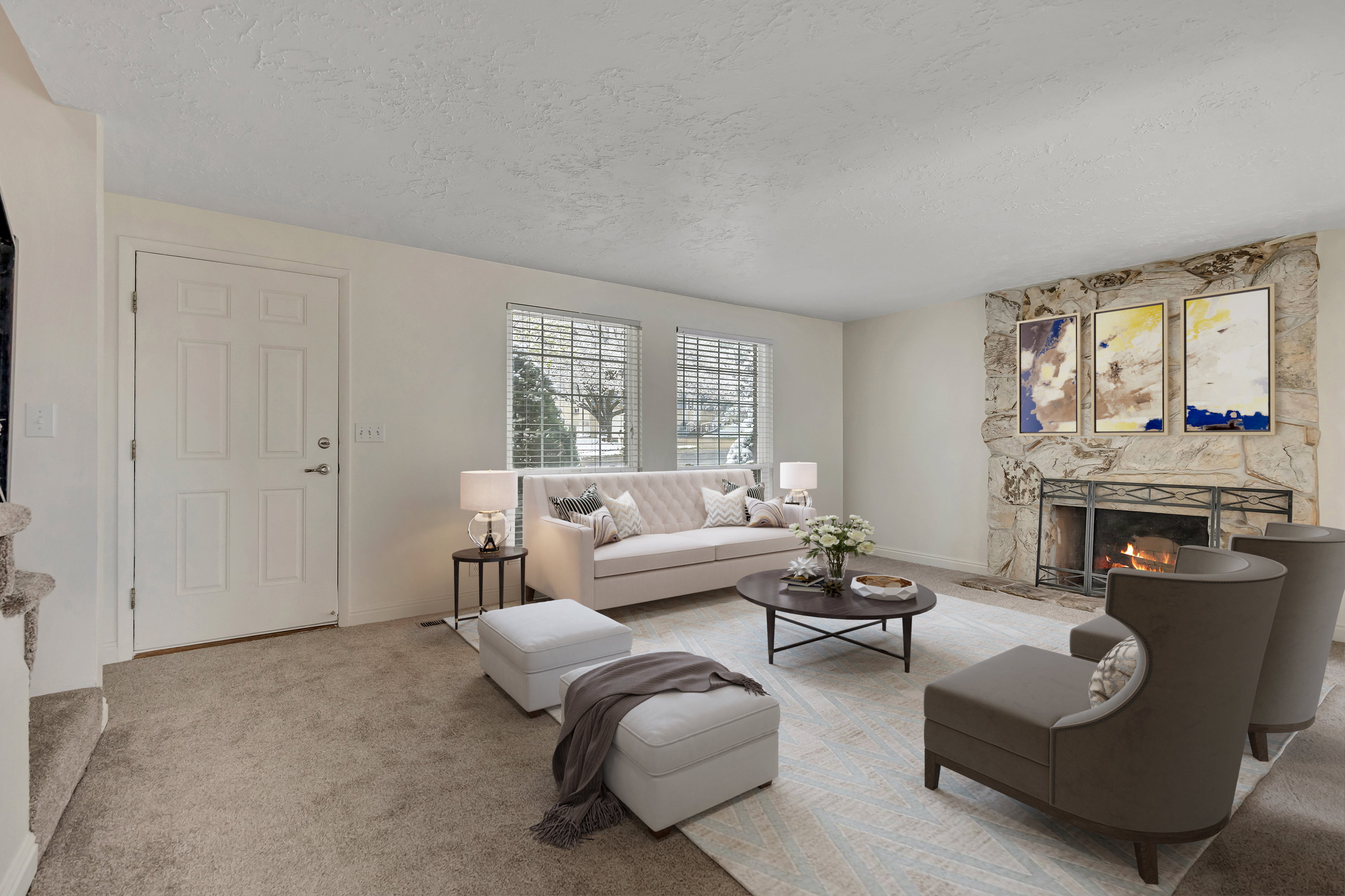 Carpeted living room featuring a textured ceiling and a stone fireplace (virtually staged)